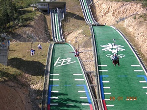 People Riding over Ecker Hill Alpine Skiing Tracks